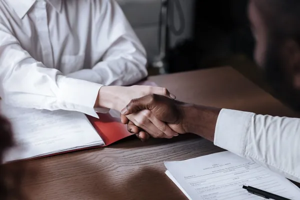 Aperto de mãos sobre a mesa fechando a contratação do empréstimo consignado na RégliCred